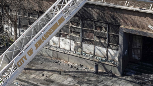 EDITORS NOTE: Graphic content / A ladder of a fire engine from the fire department of the City of Johannesburg is seen at the scene of a fire in Johannesburg on August 31, 2023. At least 20 people have died and more than 40 were injured in a fire that engulfed a five-storey building in central Johannesburg on August 31, 2023, the South African city's emergency services said. (Photo by Michele Spatari / AFP)