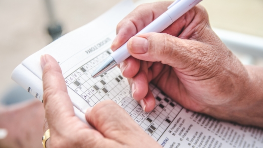 View of an old person completing a crossword puzzle