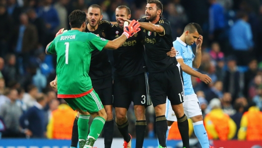 MANCHESTER, ENGLAND - SEPTEMBER 15:  Gianluigi Buffon, Leonardo Bonucci, Giorgio Chiellini and Andrea Barzagli of Juventus celebrate victory as Sergio Aguero of Manchester City look dejected after the UEFA Champions League Group D match between Manchester City FC and Juventus at the Etihad Stadium on September 15, 2015 in Manchester, United Kingdom.  (Photo by Alex Livesey/Getty Images)