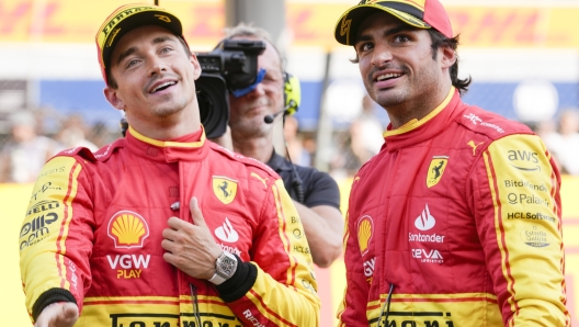 Ferrari driver Carlos Sainz of Spain, right, celebrates his pole position with third placed Ferrari driver Charles Leclerc of Monaco after the qualifying session ahead of Sunday's Formula One Italian Grand Prix auto race, at the Monza racetrack, in Monza, Italy, Saturday, Sept. 2, 2023. (AP Photo/Luca Bruno)