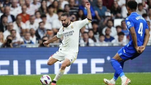 Real Madrid's Dani Carvajal, left, controls the ball past Getafe's Gaston Alvarez during Spanish La Liga soccer match between Real Madrid and Getafe at the Santiago Bernabeu stadium in Madrid, Spain, Saturday, Sept. 2, 2023. (AP Photo/Jose Breton)