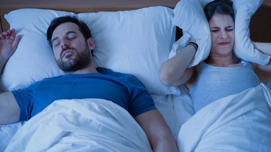 Man snoring in the bed because of night apnoea sleep disorder