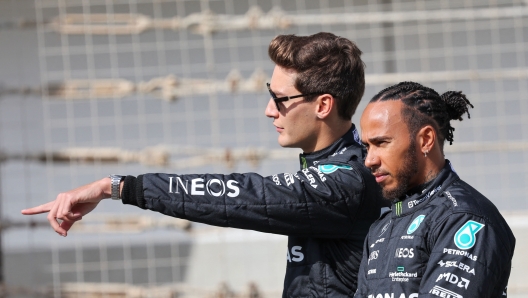 Mercedes' British driver Lewis Hamilton (R) and teammate British driver George Russell arrive for the first day of Formula One pre-season testing at the Bahrain International Circuit in Sakhir on February 23, 2023. (Photo by Giuseppe CACACE / AFP)