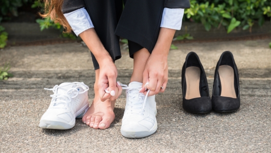 Close-up Of Businesswoman Changing Shoes On Street