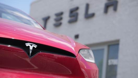 FILE - An unsold 2023 Model X sports-utility vehicle sits outside a Tesla dealership Sunday, June 18, 2023, in Littleton, Colo.  After enjoying a strong run where they could keep raising prices to boost their profits, companies are now stuck in a vise. On one end, revenue is under pressure as the global economy remains fragile. On the other, companies are having to pay higher wages for workers, among other costs. Caught in the middle are corporate profit margins, which measure how much profit companies make on each $1 of revenue.  (AP Photo/David Zalubowski, File)