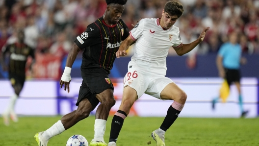 Lens' Elye Wahi fights for the ball against Sevilla's Juanlu during the Champions League Group B soccer match between Sevilla and Lens at the Ramon Sanchez-Pizjuan in Seville, Spain, Wednesday. Sept. 20, 2023. (AP Photo/Jose Breton)