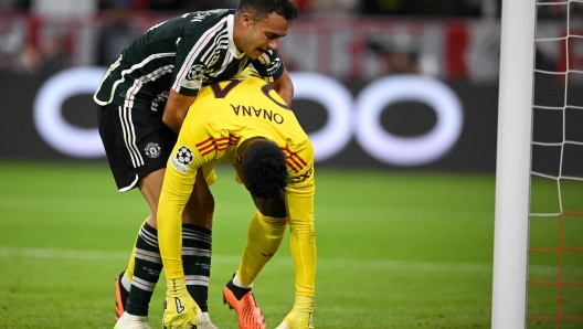 Manchester United's Spanish defender #15 Sergio Reguilon lifts up Manchester United's Cameroonian goalkeeper #24 Andre Onana after conceding the opening goal during the UEFA Champions League Group A football match FC Bayern Munich v Manchester United in Munich, southern Germany on September 20, 2023. (Photo by Tobias SCHWARZ / AFP)