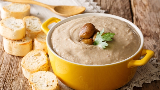 Delicious chestnut soup close-up in a pot and croutons on a table. horizontal