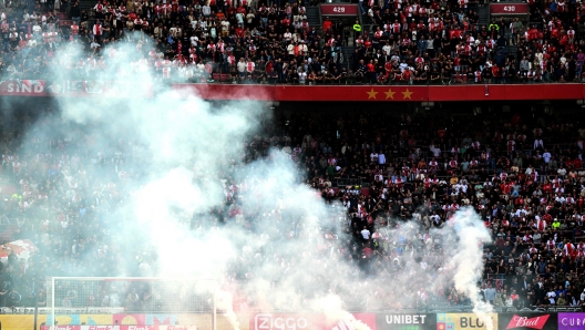 This photograph taken on September 24, 2023, shows smoke rising from fireworks thrown on the field by Ajax' supporters during the Dutch Eredivisie football match between Ajax Amsterdam and Feyenoord at the Johan Cruijff Arena in Amsterdam. (Photo by Olaf Kraak / ANP / AFP) / Netherlands OUT