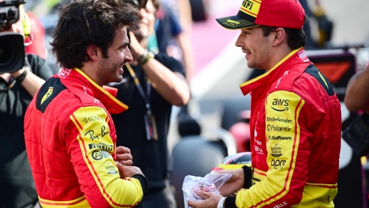 TOPSHOT - First placed Ferrari's Spanish driver Carlos Sainz Jr (L) and third placed Ferrari's Monegasque driver Charles Leclerc celebrate after the qualifying session, ahead of the Italian Formula One Grand Prix at Autodromo Nazionale Monza circuit, in Monza on September 2, 2023. (Photo by Marco BERTORELLO / AFP)