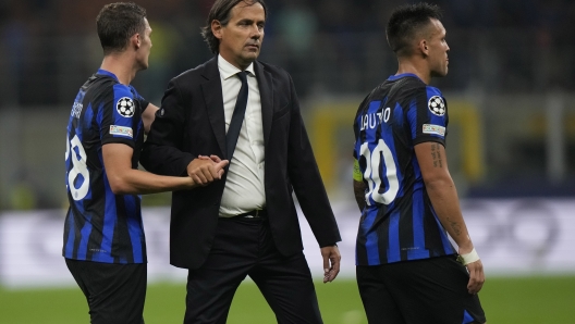 Inter Milan's head coach Simone Inzaghi, center, congratulates his players Benjamin Pavard, left, and Lautaro Martinez at the end of the Champions League, Group D soccer match between Inter Milan and Benfica, at the San Siro stadium in Milan, Italy, Tuesday, Oct. 3, 2023. Inter Milan won 1-0. (AP Photo/Luca Bruno)