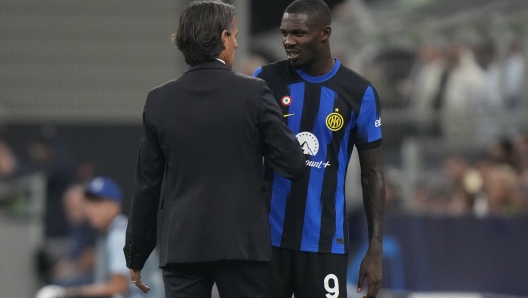 Inter Milan's head coach Simone Inzaghi, left, congratulates his player Marcus Thuram, right, after is substituted by Inter Milan's Alexis Sanchez during the Champions League, Group D soccer match between Inter Milan and Benfica, at the San Siro stadium in Milan, Italy, Tuesday, Oct. 3, 2023. (AP Photo/Luca Bruno)