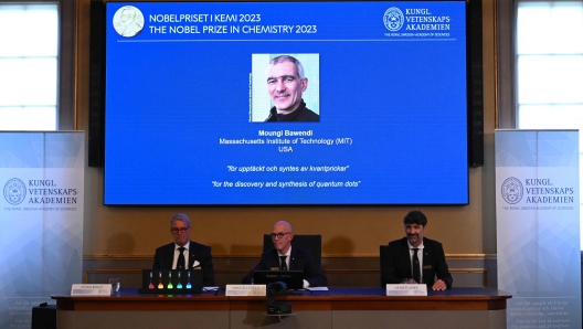 A screen shows one of this year's laureates US Chemist Moungi Bawendi as he speaks via phone to the media during the announcement of the winners of the 2023 Nobel Prize in chemistry at Royal Swedish Academy of Sciences in Stockholm on October 4, 2023. French-born Moungi Bawendi, Louis Brus of the United States and Russian-born Alexei Ekimov won the Nobel Chemistry Prize for research in semiconductor nanocrystals known as quantum dots. (Photo by Jonathan NACKSTRAND / AFP)