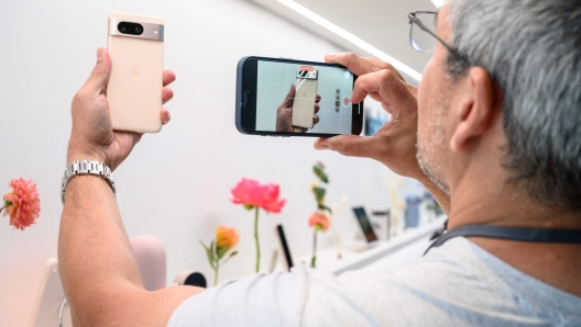 Attendees look at mobile devices during a product launch event for the Google Pixel 8, and Pixel 8 pro phones, Pixel Watch 2, and Pixel Buds Pro earbuds, in New York on October 4, 2023. (Photo by Ed JONES / AFP)