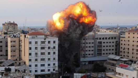 Fire and smoke rise after an Israeli air strike targeted the National Bank on Gaza City, on October 8, 2023. Israel, reeling from the deadliest attack on its territory in half a century, formally declared war on Hamas Sunday as the conflict's death toll neared 1,000 after the Palestinian militant group launched a massive surprise assault from Gaza. (Photo by Ahmed ZAKOUT / AFP)