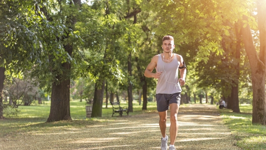 Sport fitness model training outdoor for marathon. City fitness. Running in the park.