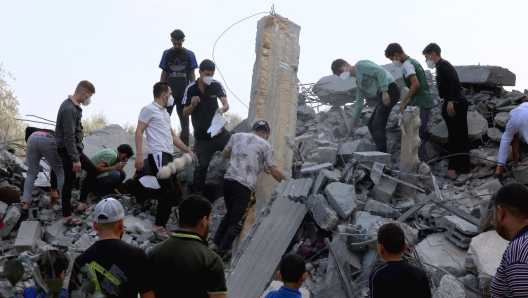 EDITORS NOTE: Graphic content / Palestinians search the rubble following an Israeli strike, as fighting between Israel and the Hamas movement continue for the eigth consecutive day, in the city Rafah, in the southern Gaza Strip on October 14, 2023. Thousands of people, both Israeli and Palestinians have died since October 7, 2023, after Palestinian Hamas militants based in the Gaza Strip, entered southern Israel in a surprise attack leading Israel to declare war on Hamas in Gaza on October 8. (Photo by SAID KHATIB / AFP)