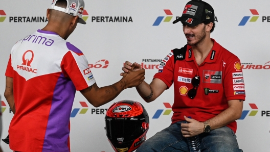 Ducati Lenovo Team rider Francesco Bagnaia of Italy (R) shakes hands with Prima Pramac Racing rider Jorge Martin of Spain during a press conference ahead of the MotoGP Indonesian Grand Prix at the Mandalika International Circuit in Kuta Mandalika, Central Lombok, on October 12, 2023. (Photo by Sonny TUMBELAKA / AFP)