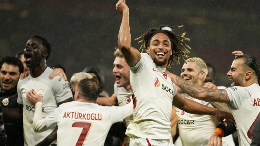 Galatasaray's players celebrate after winning the Champions League group A soccer match between Manchester United and Galatasaray at the Old Trafford stadium in Manchester, England, Tuesday, Oct. 3, 2023. Galatasaray won 3-2. (AP Photo/Dave Thompson)