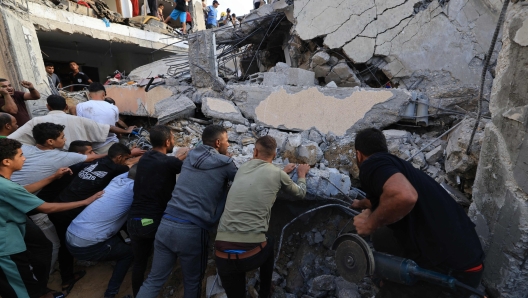 Palestinians search through the rubble of a building after an Israeli strike in Khan Yunis in the southern Gaza Strip on October 17, 2023. The death toll from Israeli strikes on the Gaza Strip has risen to around 2,750 since Hamas's deadly attack on southern Israel last week, the Gaza health ministry said October 16. (Photo by Mahmud HAMS / AFP)