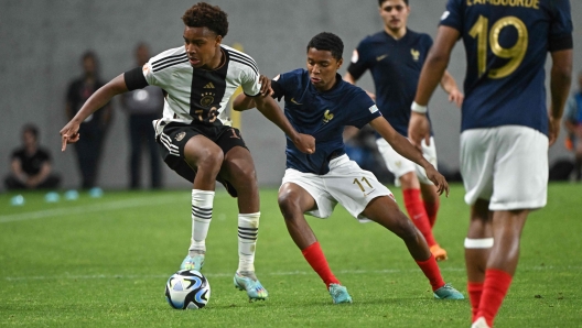 Germany's midfielder Assan Ouedraogo (L) and Frances forward Yanis Ali Issoufou vie for the ball during the UEFA Under 17 final football match between Germany and France at the Hidegkuti Nandor Stadium in Budapest, Hungary on June 2, 2023. (Photo by Attila KISBENEDEK / AFP)