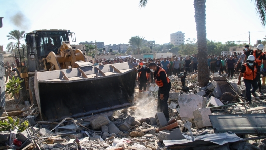 KHAN YUNIS, GAZA - OCTOBER 19: Palestinian emergency services and local citizens search for victims in buildings destroyed during Israeli air raids in the southern Gaza Strip on October 19, 2023 in Khan Yunis, Gaza. Gazans are evacuating to the south as advised by the Israeli government, ahead of an expected Israeli ground offensive. Israel has sealed off Gaza, leaving the entire population without fuel, water or aid, and launched sustained retaliatory air strikes, which have killed more than 2,000 people and some 400,000 displaced, after a large-scale attack by Hamas. On October 7, the Palestinian militant group Hamas launched a surprise attack on Israel from Gaza by land, sea, and air, killing over 1,300 people and wounding around 2,800. Israeli soldiers and civilians have also been taken hostage by Hamas and moved into Gaza. The attack prompted a declaration of war by Israeli Prime Minister Benjamin Netanyahu and the announcement of an emergency wartime government. (Photo by Ahmad Hasaballah/Getty Images)