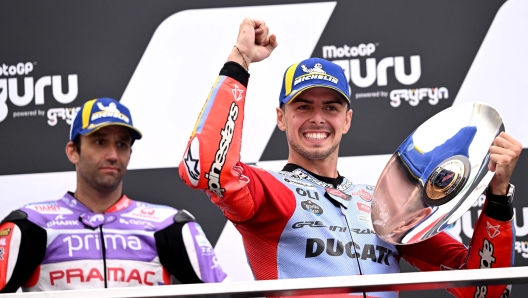 Third placed Gresini Racing's Italian rider Fabio Di Giannantonio celebrates on the podium as Prima Pramac's French rider Johann Zarco (L) looks on after the MotoGP Australian Grand Prix at Phillip Island on October 21, 2023. (Photo by WILLIAM WEST / AFP) / -- IMAGE RESTRICTED TO EDITORIAL USE - STRICTLY NO COMMERCIAL USE --