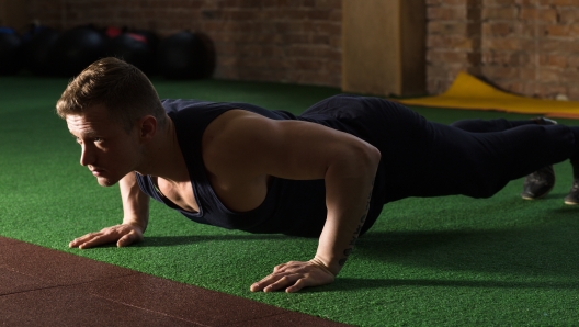 Athletic man doing push ups in gym