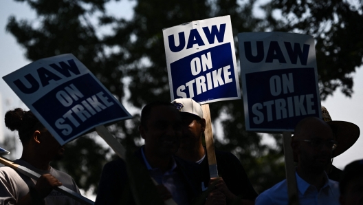 (FILES) Members of the United Auto Workers (UAW) Local 230 and their supporters walk the picket line in front of the Chrysler Corporate Parts Division in Ontario, California, on September 26, 2023, to show solidarity for the "Big Three" autoworkers currently on strike. Stellantis and the striking United Auto Workers union have reached a preliminary deal allowing members to return to factories, the union said October 28. The tentative agreement, reached after 44 days of strike action that simultaneously targeted Detroit's "Big Three" automakers, includes a 25 percent raise in base wages by 2028, the union said. "Stellantis workers will return to work while the agreement goes through the ratification process," the UAW said in a statement. (Photo by Patrick T. Fallon / AFP)