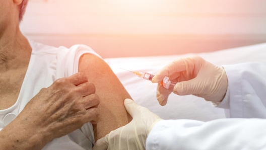 Senior vaccination concept. Elderly getting immune vaccine at arm for flu shot, pneumonia, and shingles(MMR) in hospital by nurse. Doctor giving an injection to older people patient in clinic.