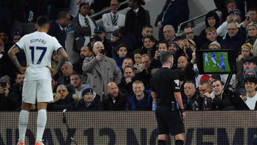 epaselect epa10961252 Tottenham's Cristian Romero (L) waits as referee Michael Oliver watches the VAR display before taking a decision on a penalty shot for Chelsea during the English Premier League soccer match between Tottenham Hotspur and Chelsea FC, in London, Britain, 06 November 2023.  EPA/VINCE MIGNOTT EDITORIAL USE ONLY. No use with unauthorized audio, video, data, fixture lists, club/league logos or 'live' services. Online in-match use limited to 120 images, no video emulation. No use in betting, games or single club/league/player publications.