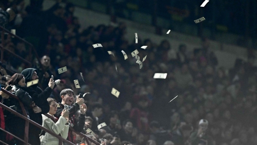 AC Milan supporters throw fake dollars to Paris Saint-Germain's Italian goalkeeper #99 Gianluigi Donnarumma before the UEFA Champions League 1st round group F football match between AC Milan and Paris Saint-Germain at the San Siro stadium in Milan on November 7, 2023. (Photo by GABRIEL BOUYS / AFP)