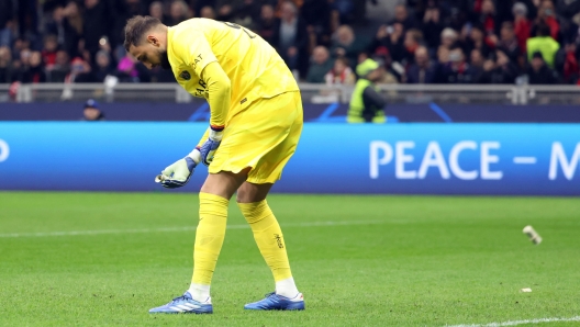 Paris Saint-German's goalkeeper Gianluigi Donnarumma  takes a roll of fake money thrown by AC Milan fans during the UEFA Champions League group F soccer match between Ac Milan and Paris Saint-German's at Giuseppe Meazza stadium in Milan, 7 November 2023. ANSA / MATTEO BAZZI