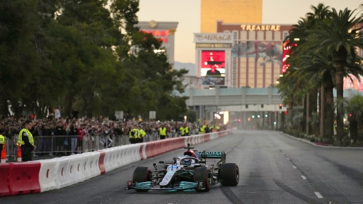 FILE - George Russell drives during a demonstration along the Las Vegas Strip at a launch party for the Formula One Las Vegas Grand Prix on Nov. 5, 2022. As the sport grows in popularity, race weekends are transforming into mini music festivals with A-list talent performing after the day's event.  (AP Photo/John Locher, File)