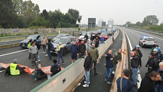 Gli attivisti di Ultima Generazione bloccano l'autostrada Torino-Milano nelle vicinanza dell'imbocco di corso Giulio Cesare, e vengono sgomberati dalle forze dell'ordine, Torino, 19 ottobre 2023. ANSA/ALESSANDRO DI MARCO