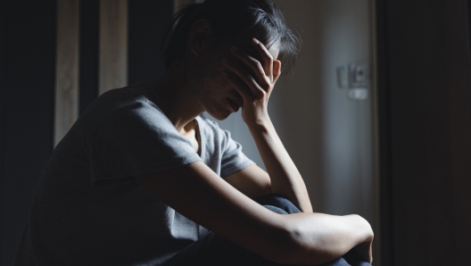 Sad woman sitting alone, woman on the bed, stress, suicidal thoughts, human trafficking