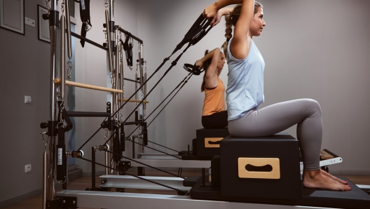 Young women exercising in a gym on pilates machines.