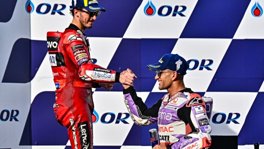 Winner Prima Pramac's Spanish rider Jorge Martin (R) greets second-placed Ducati Lenovo Team's Italian rider Francesco Bagnaia (L) on the podium after the MotoGP Thailand Grand Prix at the Buriram International Circuit in Buriram on October 29, 2023. (Photo by Lillian SUWANRUMPHA / AFP)