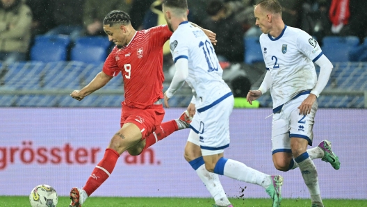 Switzerlands forward #09 Noah Okafor (L) fights for the ball with Kosovos forward #10 Zymer Bytyqi (C) and Kosovos defender #02 Florent Hadergjonaj (R) during the UEFA Euro 2024 Group I qualification football match between Switzerland and Kosovo at the Saint Jakob-Park stadium in Basel, on November 18, 2023. (Photo by SEBASTIEN BOZON / AFP)