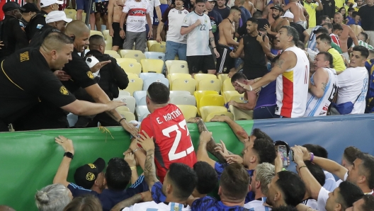 epa10988744 Emiliano Martinez (C) goalkeeper of Argentina tries to controls a clash between fans prior a FIFA 2026 World Cup qualifiers soccer match between Brazil and Argentina at Maracana stadium in Rio de Janeiro, Brazil, 21 November 2023.  EPA/Andre Coelho