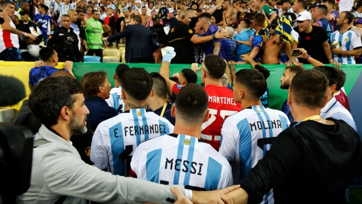 RIO DE JANEIRO, BRAZIL - NOVEMBER 21: Lionel Messi of Argentina and teammates react as police officers clash with fans prior to a FIFA World Cup 2026 Qualifier match between Brazil and Argentina at Maracana Stadium on November 21, 2023 in Rio de Janeiro, Brazil. The match was delayed due to incidents in the stands. (Photo by Wagner Meier/Getty Images)