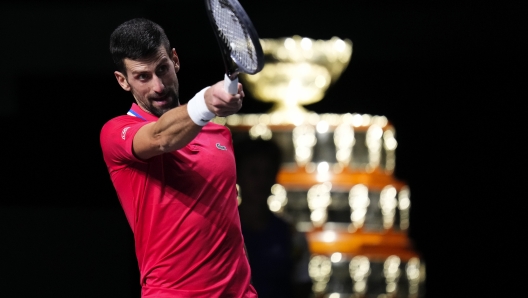 Serbia's Novak Djokovic reacts, with the Davis Cup on the background, during a Davis Cup quarter-final tennis match against Britain's Cameron Norrie in Malaga, Spain, Thursday, Nov. 23, 2023. (AP Photo/Manu Fernandez)