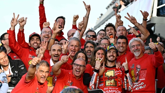 TOPSHOT - Ducati Italian rider Francesco Bagnaia (R) celebrates with his team after winning the MotoGP Valencia Grand Prix at the Ricardo Tormo racetrack in Cheste, on November 26, 2023. Italy's Francesco Bagnaia enjoyed a dream day as he retained his MotoGP world title and crowned it with victory in the final race of the season in Valencia today. The 26-year-old Ducati rider had been assured of the championship when his sole rival Jorge Martin crashed early in the race. (Photo by JAVIER SORIANO / AFP)