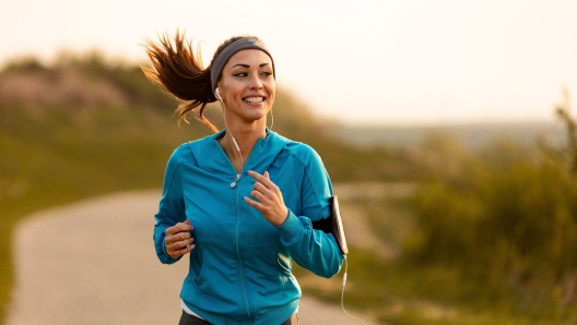 Dedicated athletic woman running in nature and dawn.