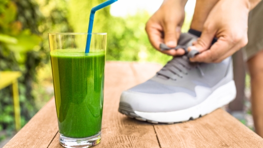 Man tying shoe next to healthy shake.