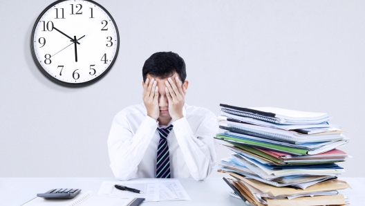 Portrait of exhausted young businessman sitting at office desk