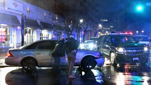 Members of the US Secret Service rush to a car, after it hit a motorcade SUV, as US president Joe Biden was leaving his campaign headquarters in Wilmington, Delaware on December 17, 2023. (Photo by ANDREW CABALLERO-REYNOLDS / AFP)