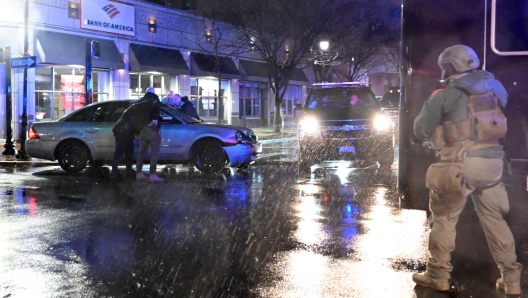 Members of the US Secret Service rush to a car, after it hit a motorcade SUV, as US president Joe Biden was leaving his campaign headquarters in Wilmington, Delaware on December 17, 2023. (Photo by ANDREW CABALLERO-REYNOLDS / AFP)