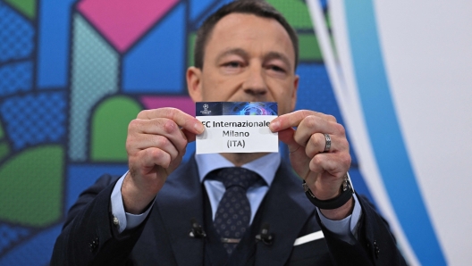 UEFA Champions League ambassador and British former football player, John Terry holds the paper slip of FC Internazionale Milano during the 2023-2024 UEFA Champions League football tournament round of 16 draw at the House of European Football in Nyon, on December 18, 2023. (Photo by Fabrice COFFRINI / AFP)