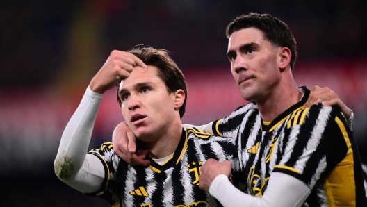 Juventus' Italian forward #07 Federico Chiesa celebrates with Juventus' Serbian forward #09 Dusan Vlahovic (R) after scoring a penalty during the Italian Serie A football match between Genoa and Juventus at the Luigi Ferraris stadium, on December 15, 2023. (Photo by Marco BERTORELLO / AFP)